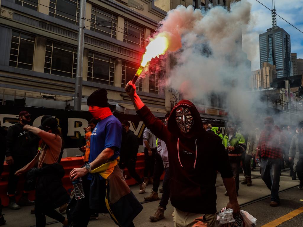 Protesters are seen marching as a flare is lit as thousands march through Melbourne. Picture: Getty Images