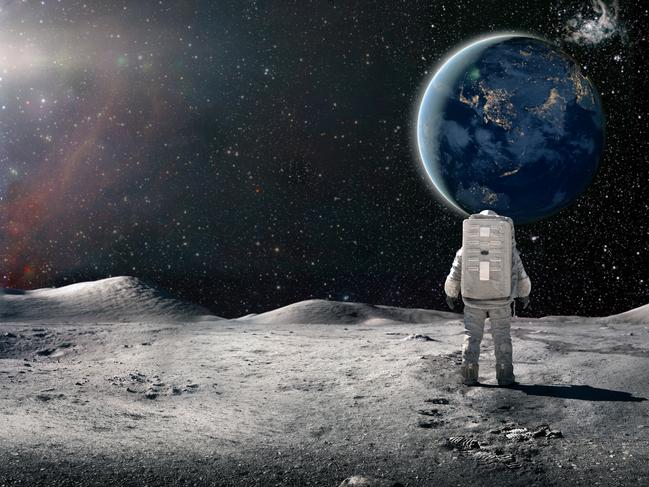 A single astronaut viewed from behind, standing and looking at the sun rising over a distant plant earth surrounded by distant stars and galaxies. The astronaut is wearing a conventional white spacesuit with backpack. Earth image from NASA: https://eoimages.gsfc.nasa.gov/images/imagerecords/79000/79790/city_lights_asia_night_8k.tif