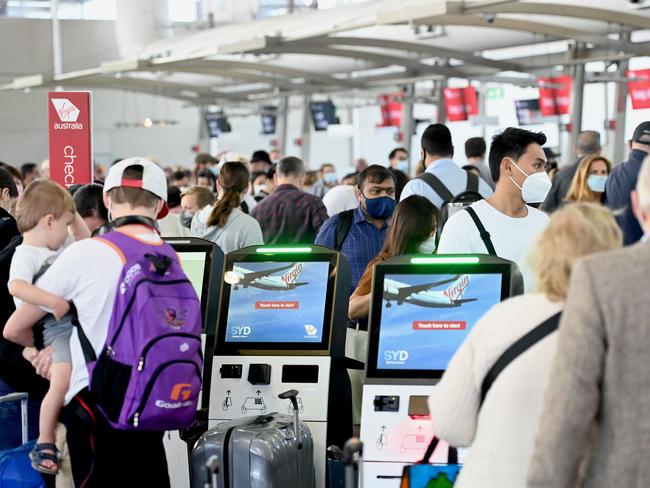 Holiday makers at Sydney Domestic Airport queue at the check in.