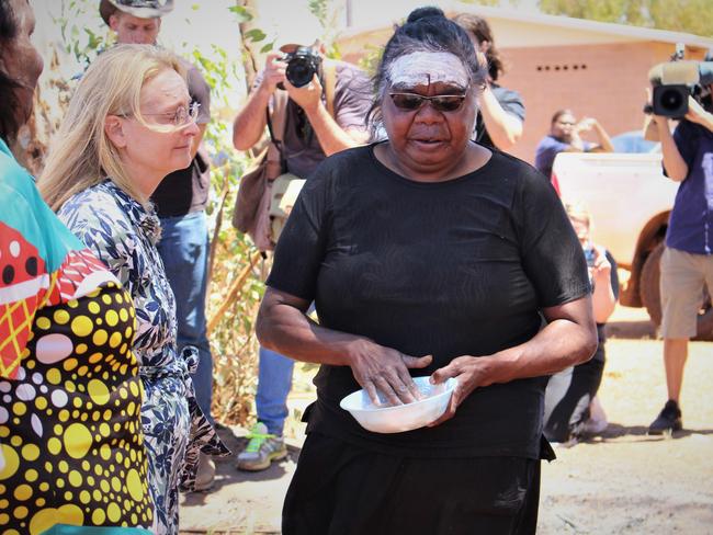 Kumanjayi Walker's mother Leeanne Oldfield paints Coroner Elisabeth Armitage’s forehead during a court visit to Yuendumu in November. Picture: Jason Walls