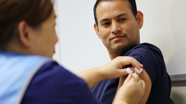 Nurse Durga Basnet receives the Covid vaccine by Nga Tran at the Lyell McEwin Hospital in Elizabeth. Picture: David Mariuz