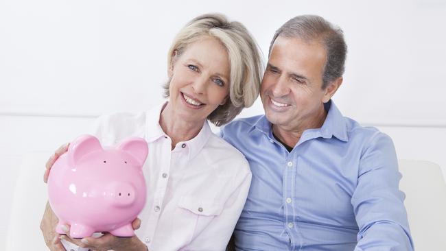 Happy Mature Couple Calculating Coin In The Piggybank. Budget management and savings. For the Good Life feature Wk 43 budgeting.