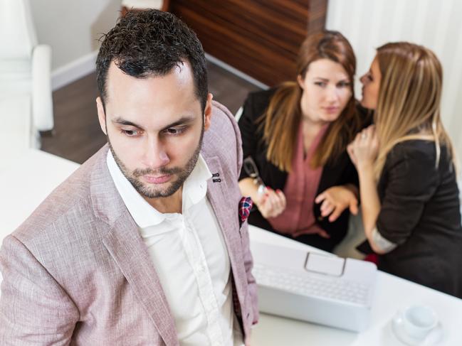 Gossip girls at office, handsome businessman portrait and gossip girls out of focus in background.