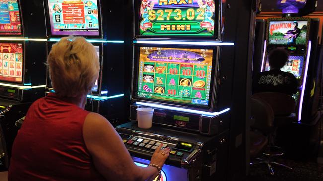 A woman tries her luck on a pokie machine.