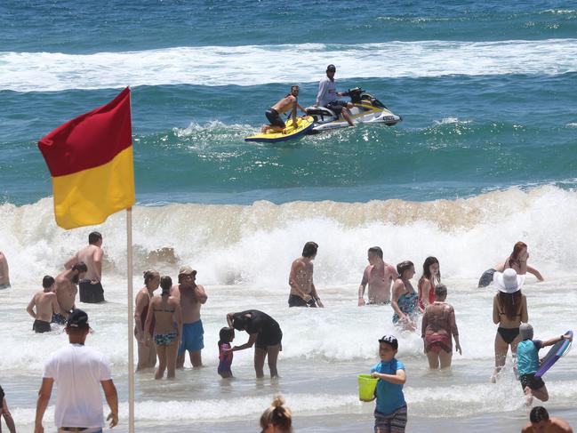 Lifeguards at Surfers Paradise beach keep an eye on beachgoers and keep them swimming between the flags on one of the busiest days of the year. Picture Glenn Hampson