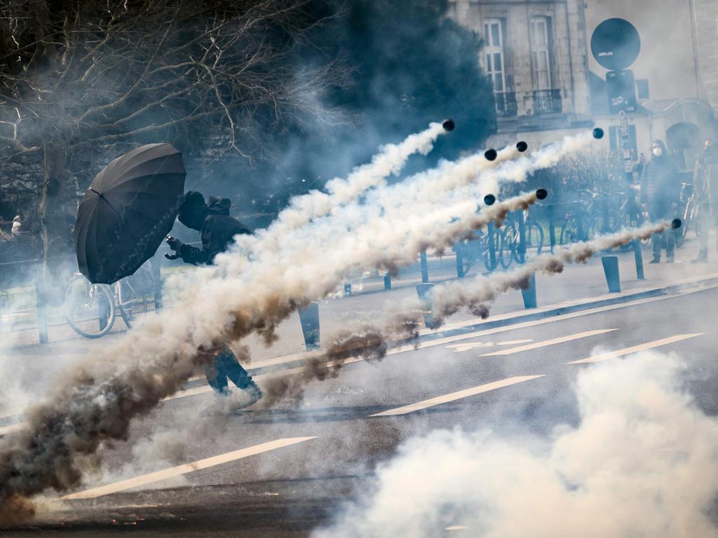 A protester holds an umbrella to protect from teargas during strikes and protests across France country against the government's proposed pensions overhaul. Picture: Loic Venance/AFP