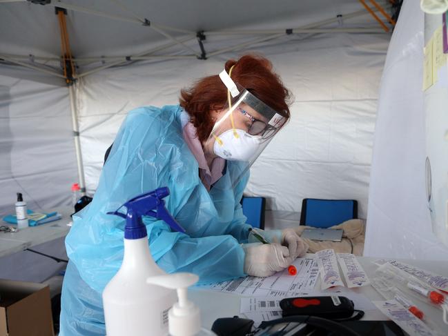 Ruth Harris from Sullivan Nicolaides takes patient details as COVID-19 testing is carried out at Bowen Hills. Picture: NCA NewsWire/Richard Gosling