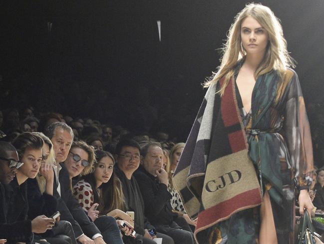 Delevingne walks the runway, as Weinstein looks on, at Burberry Womenswear Autumn/Winter 2014 at Kensington Gardens in London in 2014. Picture: Getty