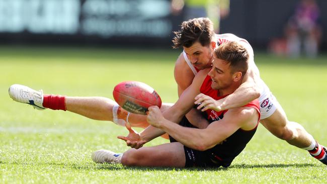 Dom Tyson gets a handball away as he is tackled by St Kilda's Koby Stevens 