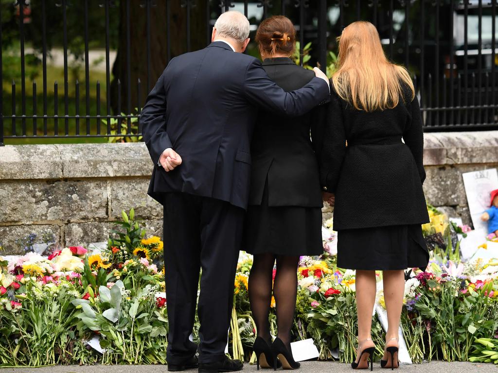 Prince Andrew consoles his daughters. Picture: AFP