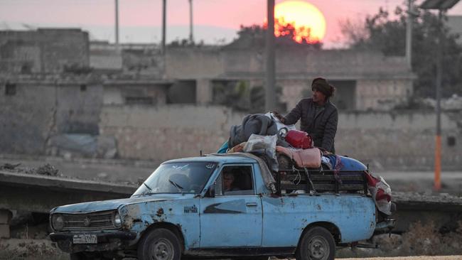 Displaced Syrian Kurds drive a ute loaded with belongings on the Aleppo-Raqqa highway to flee areas on the outskirts of the northern city of Aleppo. Picture: AFP