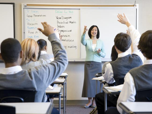 Generic photo of high school students in class answering questions. Teacher.