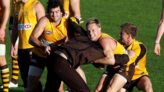 Jordan Lewis and Sam Mitchell lay a tackle on assistant coach Damien Hardwick. Hawthorn football club training at Waverley this afternoon.