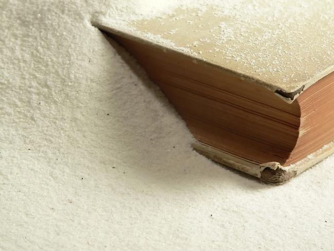 A rare and weathered book buried in fine white sand