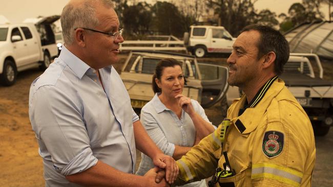 Scott and Jenny Morrison with Cobargo RFS captain Mark Ayliffe at the burnt-out NSW town on Thursday. Picture: Sean Davey.