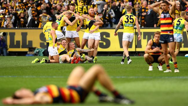 Richmond players celebrate as Adelaide players collapse.