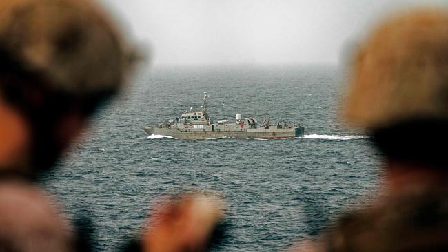 This handout picture taken by the US Navy on August 12, 2019, shows US sailors aboard an amphibious transport dock ship as they keep watch on Iranian fast attack craft in the Strait of Hormuz.