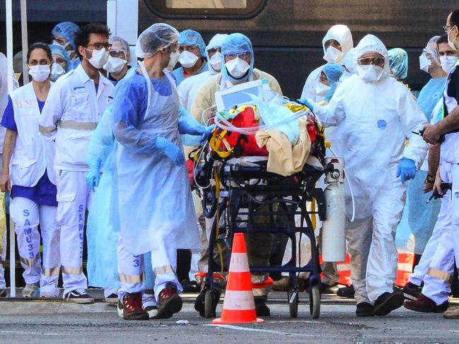 Medical workers take a coronavirus patient from a medicalised TGV high speed train at Bordeaux, France. Picture: AFP