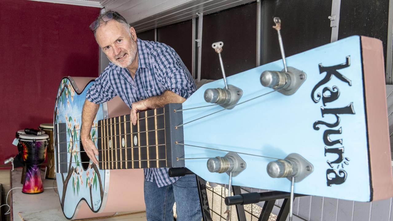 Tony Watson with the giant ukulele he made for a friend. It now resides at Bandland in Russell St. Picture: Nev Madsen