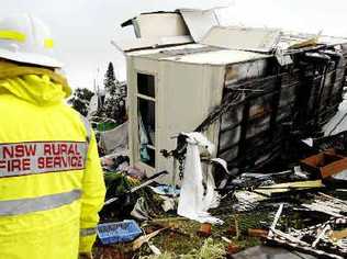 WRECKED: A NSW Rural Fire Service firefighter inspects a wreckedcaravan at the Lake Ainsworth Caravan Park after yesterday’s tornado. Picture: Jay Cronan