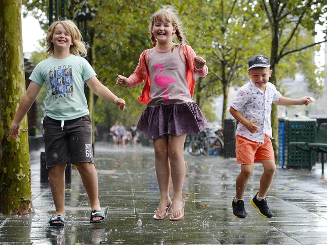 Stormy rain in Melbourne didn't stop siblings Darcy, 10, Chelsea, 8, and Mcleod, 6, who enjoyed the downpour. Picture: Josie Hayden