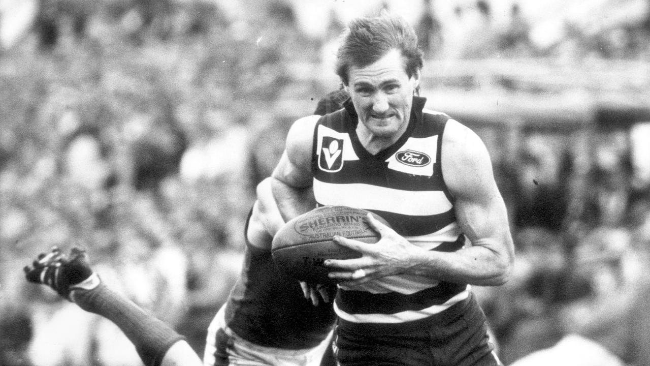 Michael Turner get away from Robert Flower in 1984. Turner was named in Geelong’s team of the century.