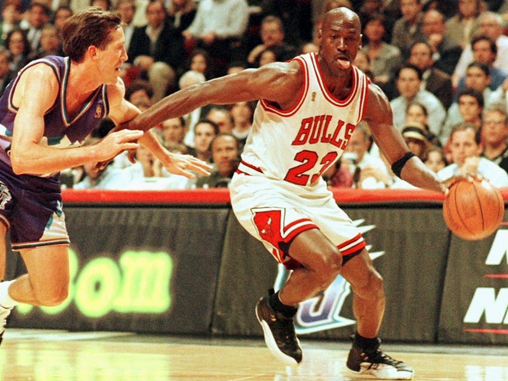 (FILES) In this file photo taken on June 4, 1997 former Chicago Bulls player Michael Jordan sticks out his tongue as he goes past Jeff Hornacek of the Utah Jazz during game two of the NBA Finals at the United Center in Chicago, IL. - Michael Jordan believes the Chicago Bulls 1990s NBA dynasty would have stayed together for at least one more season if team chiefs had backed coach Phil Jackson.  The retired legend made his comments in the last chapter of hit documentary "The Last Dance", saying he would have re-signed a one-year deal had management kept the team together, including Dennis Rodman, Scottie Pippen and Jackson. (Photo by VINCENT LAFORET / AFP)