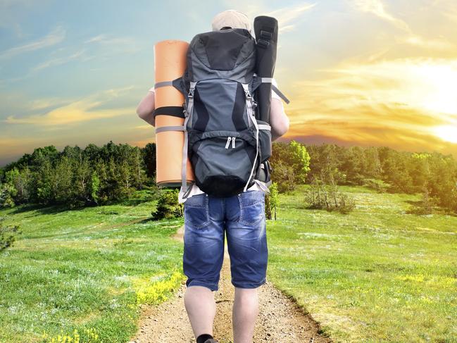 Man with a backpack walking on a country road