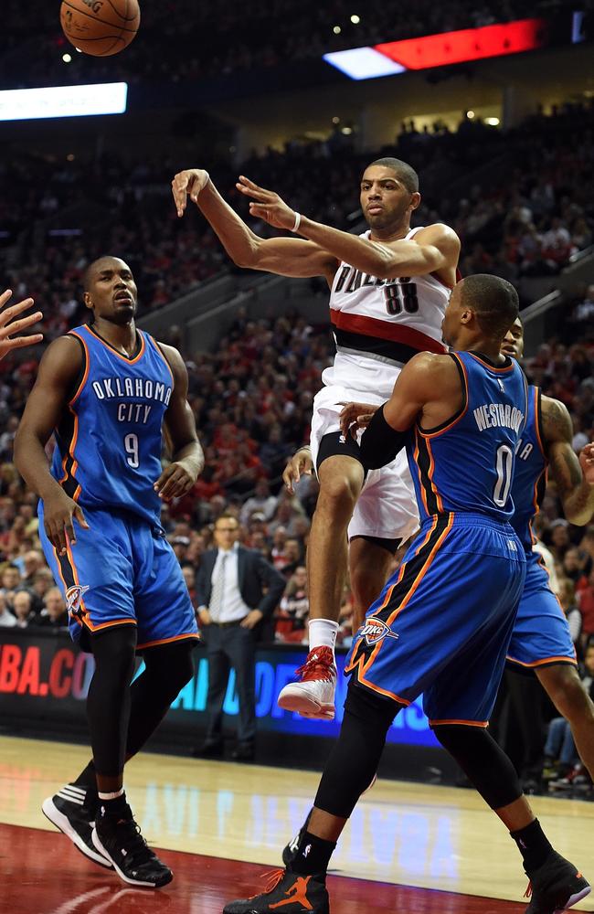 Nicolas Batum of the Portland Trail Blazers drives to the basket on Serge Ibaka #9 and Russell Westbrook #0 of the Oklahoma City Thunder.