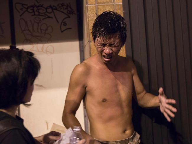 A protester reacts after police used pepper spray against him. Picture: Isaac Lawrence/AFP