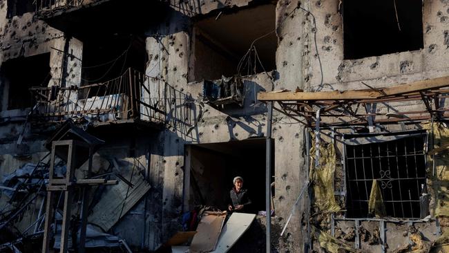 A woman stands by a windowless window in her destroyed residential building following a strike in Dobropillia, Donetsk region, on March 8. Picture: Tetiana Dzhafarova / AFP