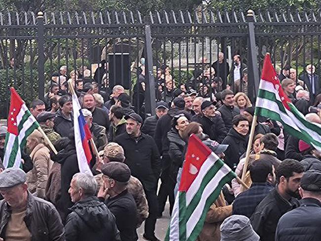 In this photo taken from video released by AIASHARA Independent Agency, Protesters with Abkhazian flags gather outside the parliament building of the Georgian separatist region of Abkhazia as tensions flared over a proposed pact that would allow Russians to buy apartments in the region, Georgia, on Friday, Nov. 15, 2024, (AIASHARA Independent Agency via AP)