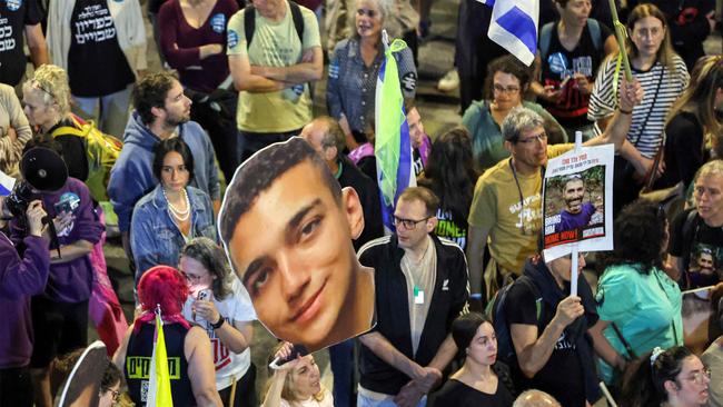 A protester holds a sign showing the face of Israeli-US hostage Edan Alexander outside the Israeli Defence Ministry headquarters in Tel Aviv in March. Picture: AFP