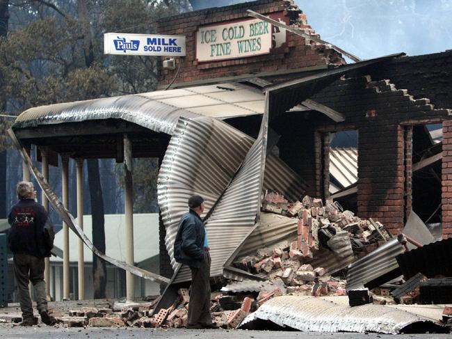  Noel Bennett and Ron Forden look at the remains of the Kinglake West general store in the immediate aftermath of Black Saturday.