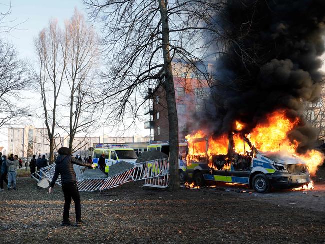 Police vans on fire in rioting in Orebro on April 15. Picture: AFP