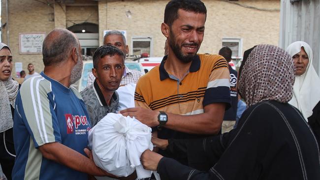 People react as they transport the body of a family member from the al-Maamadani hospital for burial, following an Israeli strike that killed more than 90 people on a school sheltering displaced Palestinians in Gaza City. Picture: Omar Al-Qattaa/AFP