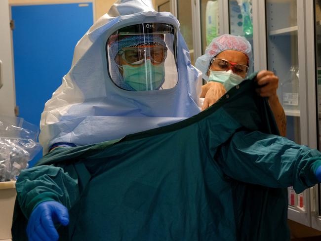 A nurse helps a colleague to dress up to enter an intensive care unit in Rome. Picture: AP