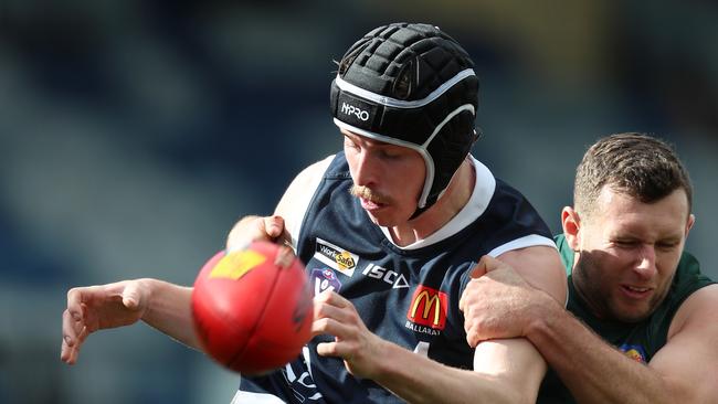 Ballarat’s Izaac Grant tries to clear the ball as Hampden’s Mitchell Bidmade tackles. Picture Yuri Kouzmin