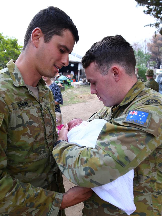 Australian Army soldiers Private Nicholas Brimmer and Private Murray Rickey hold baby Ivy Tyrrell. Picture: ADF