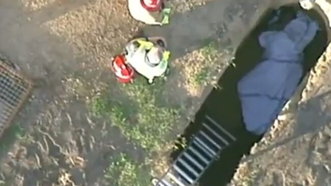 Crews are working to free a man trapped in a grave at Eltham. Picture: ABC