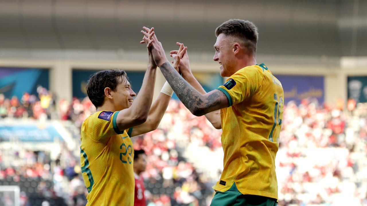 Craig Goodwin (left) and Harry Souttar celebrate the Socceroos’ fourth goal against Indonesia. Picture: Lintao Zhang/Getty Images