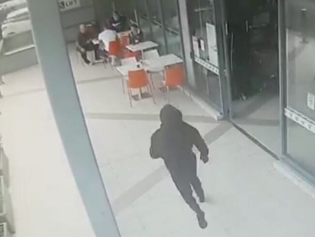 CCTV shows a hooded figure approach Walid Ahmad at Centro Bankstown. There is no suggestion the men arrested this week were linked to the hit.