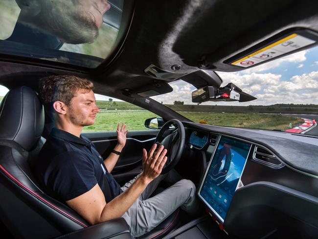 A test driver removes his hands from the steering wheel of a Tesla Motors Inc. Model S electric automobile fitted with self driving technology, developed by Robert Bosch GmbH, during the Bosch mobility experience in Boxberg, Germany, on Tuesday, July 4, 2017. Auto supplier Bosch will build a 1 billion-euro ($1.1 billion) semiconductor plant, the biggest single investment in its history, as the maker of brakes and engines prepares for a surge in demand for components used in self-driving vehicles. Photographer: Andreas Arnold/Bloomberg