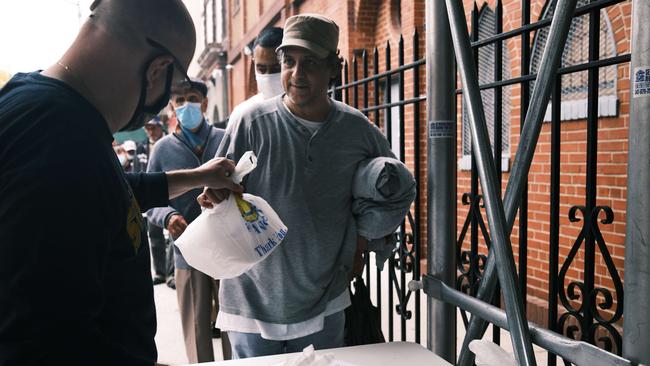 Residents receive a prepared meal at the Thessalonica Christian Church during a distribution on October 22. Picture: Getty