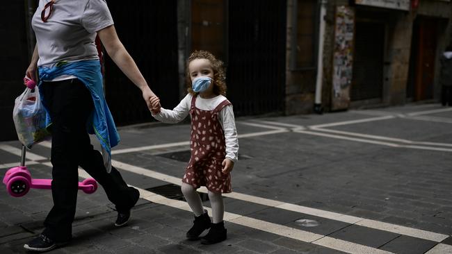 A little girl wears a face mask as she goes for a walk with her mother. (AP Photo/Alvaro Barrientos)