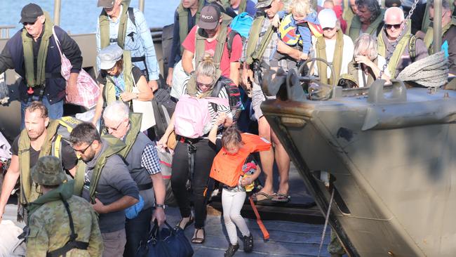 Evacuees from the Victorian south coast tourist township of Mallacoota are assisted by defence force staff. Picture: Wayne Taylor