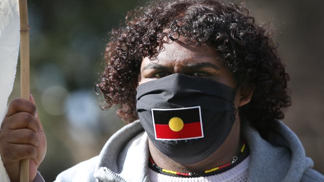 A protester wears a face mask depicting the Aboriginal flag during a rally in Sydney against Aboriginal and Torres Strait Islander deaths in custody. Picture: Getty