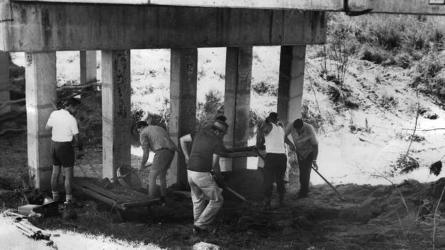 Police digging and sifting soil under the Sensible Creek railway bridge west of Charters Towers on November 18, 1972 where the skeleton of Robin Hoinville-Bartram was found three days earlier.