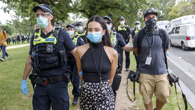 Sunday Herald Sun reporter Olivia Jenkins and photographer Jake Nowakowski are led away by police in handcuffs. Picture: NCA NewsWire / David Geraghty