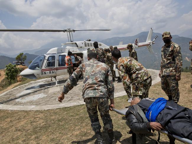 A helicopter waits to evacuate an injured elderly man at a Nepalese army base near Chautara, Nepal, Wednesday, May 13, 2015. Nepal, just beginning to rebuild after a devastating April 25 earthquake, was hit by a magnitude-7.3 quake Tuesday. The May 12 quake battered Chautara, a foothills town that became a hub for rescuers and humanitarian aid after the first earthquake.(AP Photo/Bernat Amangue)